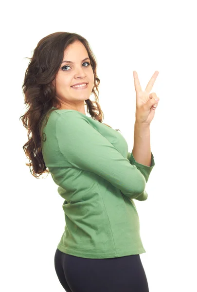 Atrakcyjny uśmiechający się dziewczyna w zielonej koszuli pokazuje jej lewej, — Zdjęcie stockowe