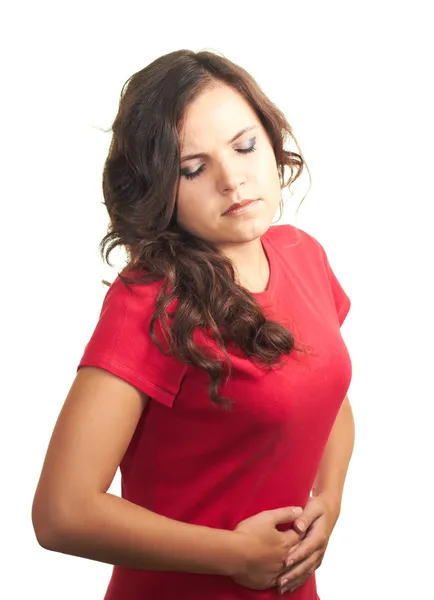 Atrakcyjny dziewczynka w czerwonej koszuli cierpi na ból brzucha. — Zdjęcie stockowe