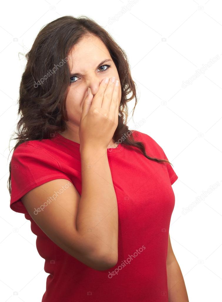Attractive girl in a red shirt from the stench covers the nose.