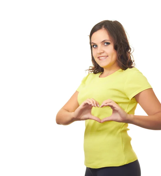 Attraktives lächelndes Mädchen im gelben Hemd macht das Herzenszeichen — Stockfoto