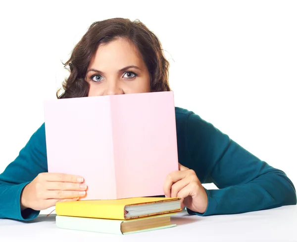 Attraktives Mädchen in blauem T-Shirt sitzt am Tisch und deckt — Stockfoto