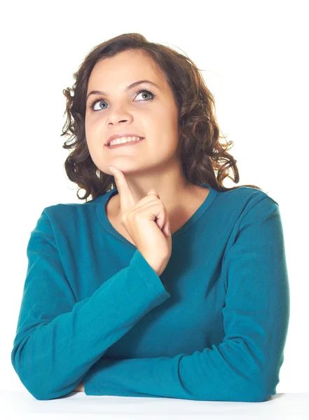 Atractiva chica sonriente en una camisa azul sueña y sosteniendo su f — Foto de Stock