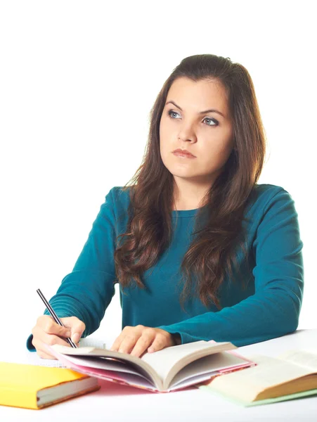 Aantrekkelijke jonge meisje in een blauw shirt zitten aan de tafel en w — Stockfoto