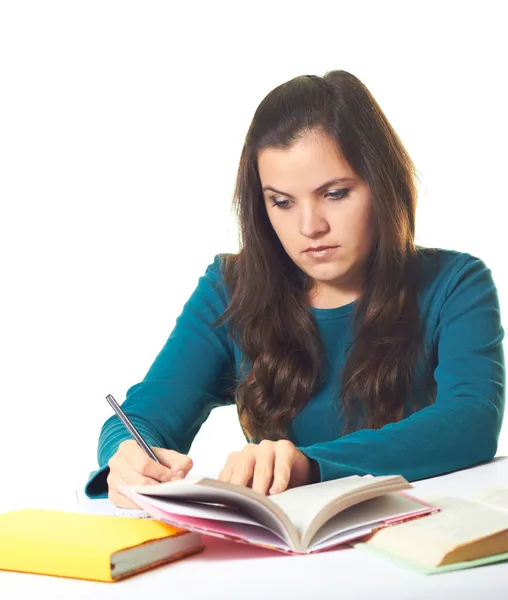 Aantrekkelijke jonge meisje in een blauw shirt zitten aan de tafel en — Stockfoto