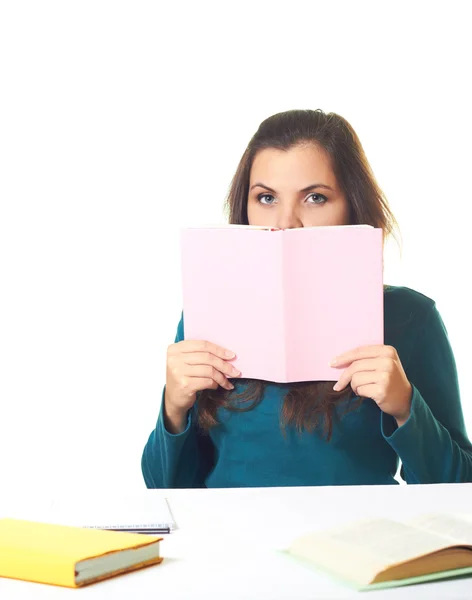 Attraktives junges Mädchen in blauem Hemd am Tisch sitzend und — Stockfoto