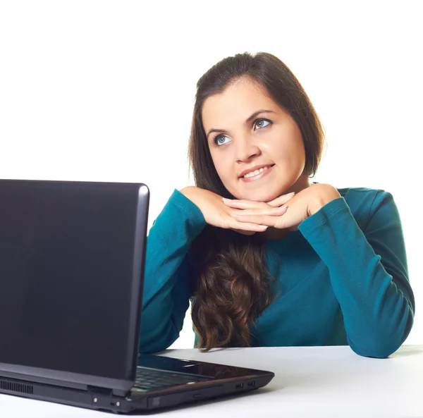 Aantrekkelijke jonge lachende meisje in een blauwe shirt die op laptop werkt. — Stockfoto