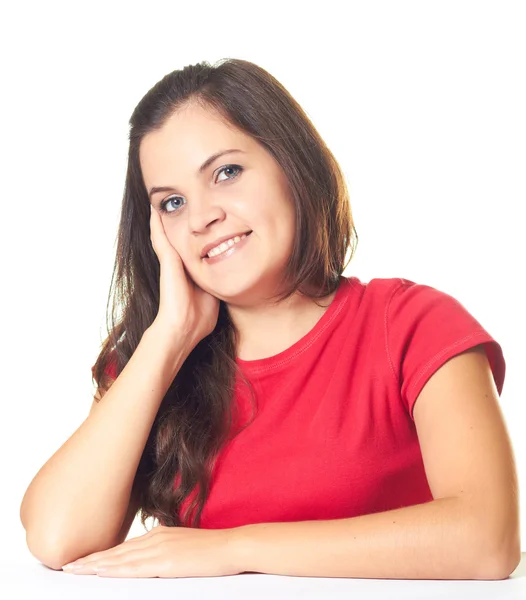 Attrayant jeune fille souriante dans une chemise rouge assis à la table — Photo