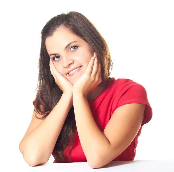 Attraktiv ung leende flicka i en röd tröja som sitter vid bordet — Stockfoto