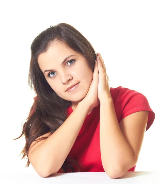 Menina atraente em camisa vermelha sentada à mesa com fol — Fotografia de Stock