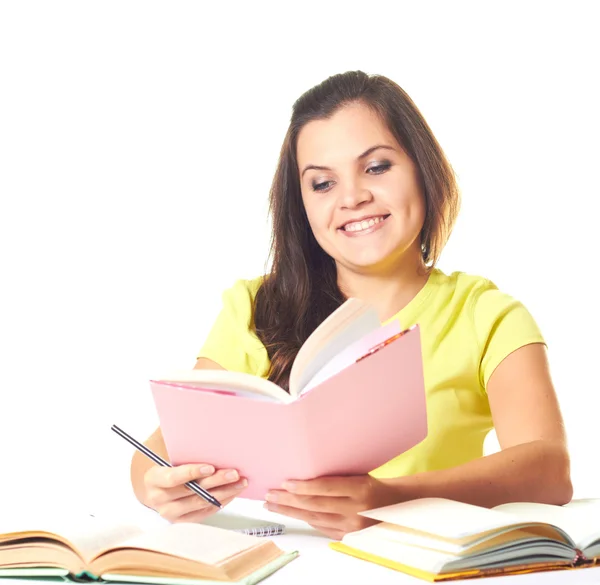 Attractive smiling girl in yellow shirt sitting at a table and r — Stock Photo, Image