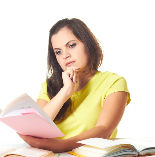 Attractive smiling girl in yellow shirt sitting at the table and — Stock Photo, Image