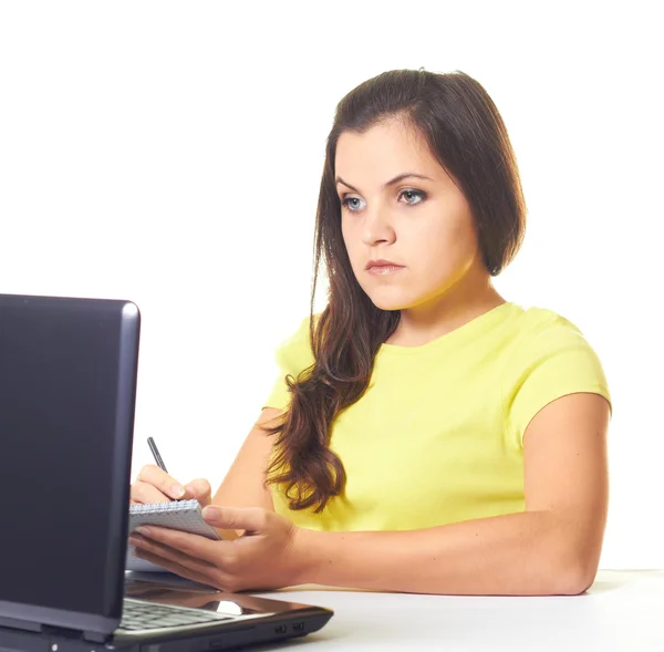 Attraktives junges Mädchen im gelben Hemd, das am Laptop arbeitet und — Stockfoto