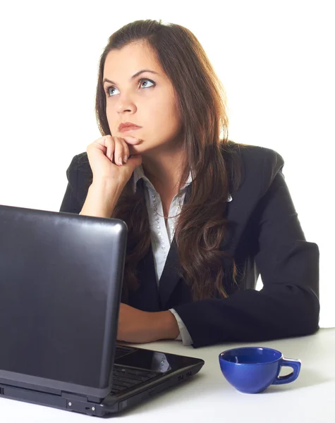 Attractive smiling girl in a black blazer, working on a laptop, Royalty Free Stock Photos