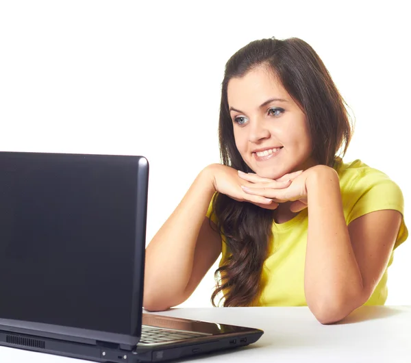 Attractive smiling girl in yellow shirt sitting at the table and — Stock Photo, Image