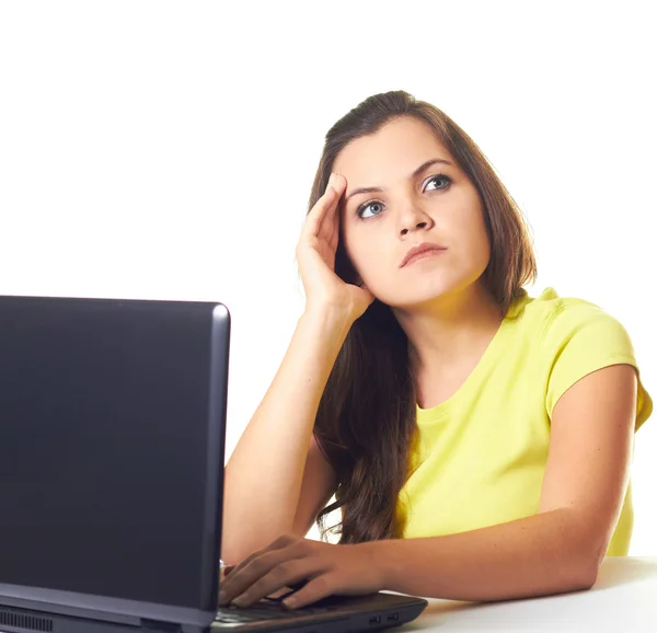 Привлекательная молодая женщина в желтой рубашке работает на ноутбуке и я — стоковое фото