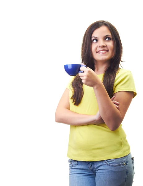 Atractiva joven con una camisa amarilla bebiendo de un cu azul — Foto de Stock