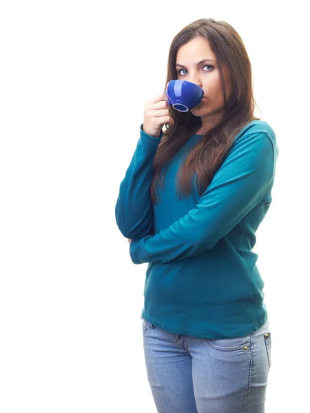 Attractive young woman in a blue shirt drinking from a blue cup. — Stock Photo, Image