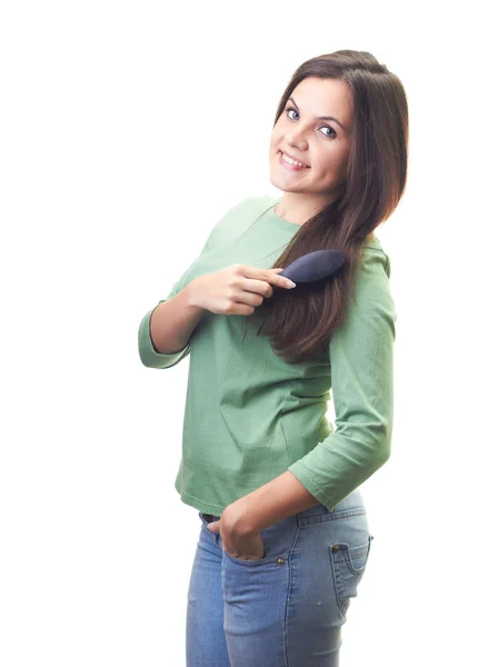 Atraktivní usměvavá mladá žena v zelené tričko čistit její hai — Stock fotografie