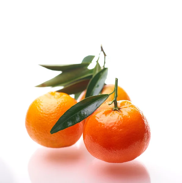 One mandarin with green leaf, a slice of mandarin and a glass of tangerine juice. On a white background — Stock Photo, Image