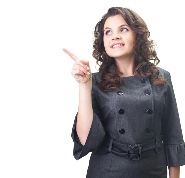 Attractive smiling young woman in a gray business dress shows he — Stock Photo, Image