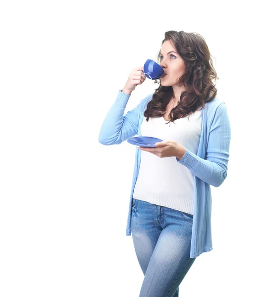 Aantrekkelijke jonge vrouw in een blauw shirt drinken uit een blauwe kopje. — Stockfoto