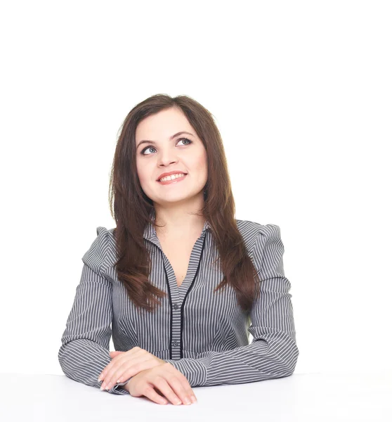Attraktive lächelnde junge Frau in einer grauen Bluse sitzt am T — Stockfoto