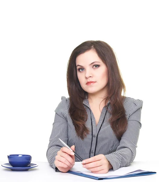 Aantrekkelijke jonge vrouw in een grijze blouse zitten aan de tafel. doen — Stockfoto