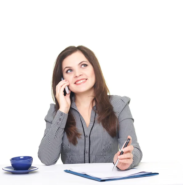 Attractive smiling young woman in a gray blouse sitting at the t — Stock Photo, Image