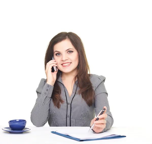 Attractive smiling young woman in a gray blouse sitting at the t — Stock Photo, Image