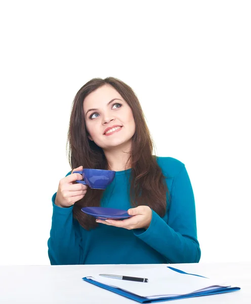 Atraktivní usměvavá mladá žena v modré košili, sedí u ta — Stock fotografie