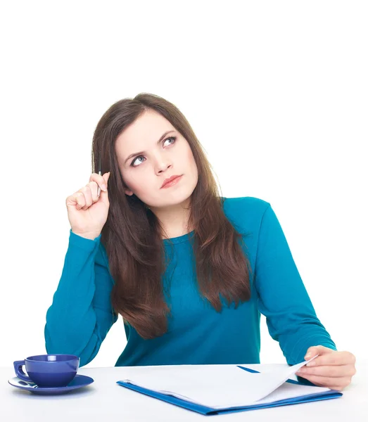 Attractive young woman in a blue shirt sitting at the table and — Stock Photo, Image