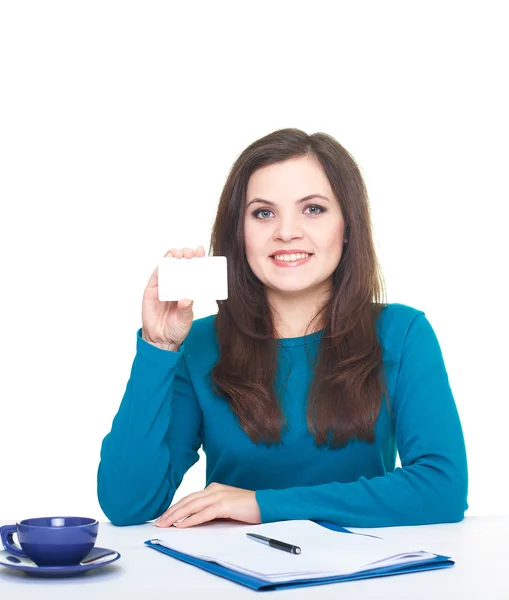 Attractive smiling young woman in a blue shirt sitting at the ta — Stock Photo, Image