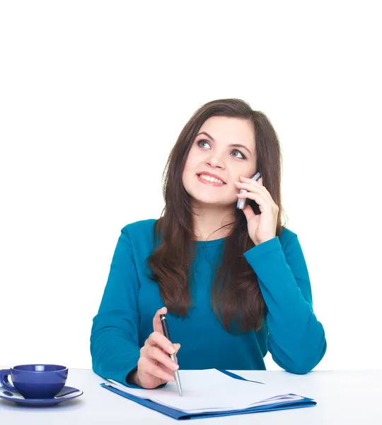 Atractiva joven sonriente con una camisa azul sentada en una mesa —  Fotos de Stock