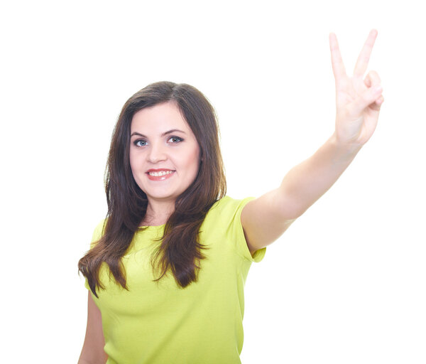 Привлекательная улыбающаяся молодая женщина в жёлтой рубашке показывает свою левую
