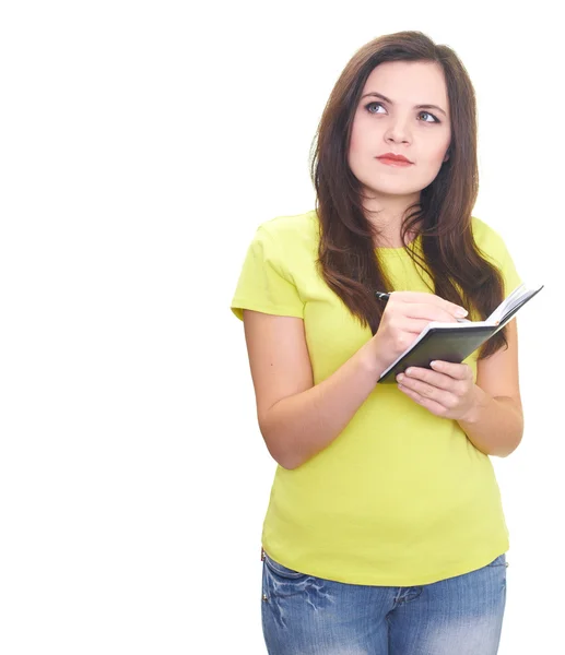 Attractive smiling young woman in yellow shirt writing something — Stock Photo, Image