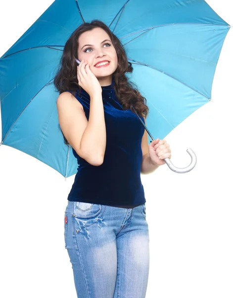 Attractive smiling young woman in a blue shirt standing under a — Stock Photo, Image