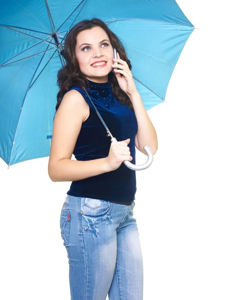 Attractive smiling young woman in a blue shirt standing under a — Stock Photo, Image