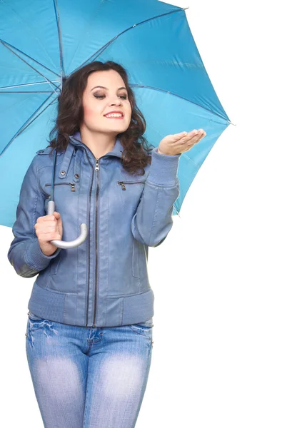 Attractive smiling young woman in a gray jacket standing under a — Stock Photo, Image