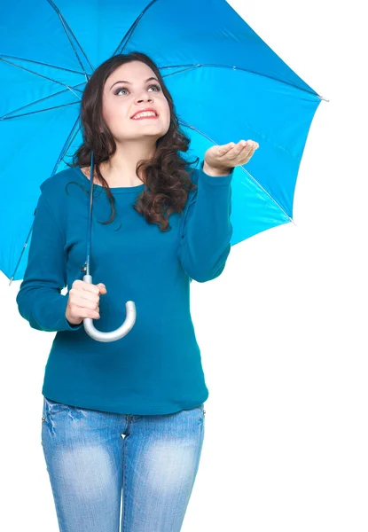 Attractive smiling young woman in a blue shirt standing under a — Stock Photo, Image