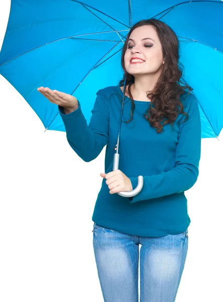 Attractive smiling young woman in a blue shirt standing under a — Stock Photo, Image