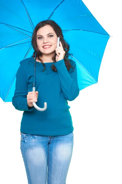 Attractive smiling young woman in a blue shirt standing under a — Stock Photo, Image