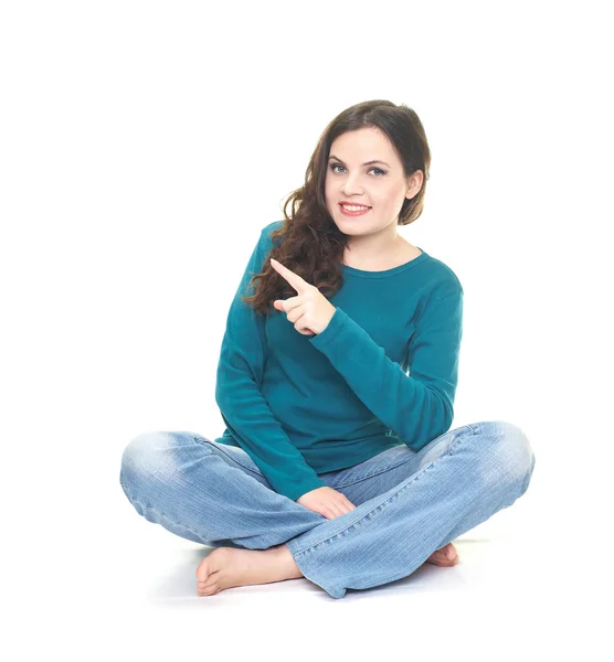 Szczęśliwa młoda kobieta w niebieską koszulę i niebieskie dżinsy siedzi — Zdjęcie stockowe
