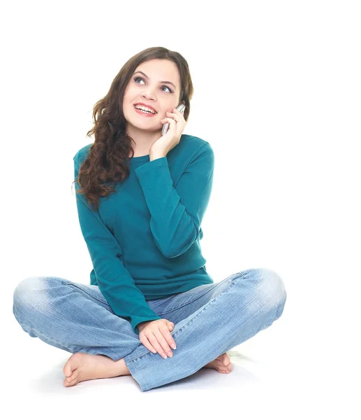 Happy young woman in a blue shirt and blue jeans sitting on the — Stock Photo, Image