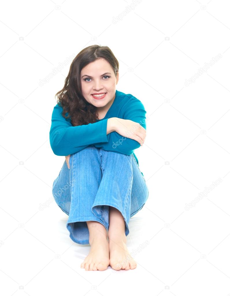 Attractive young woman in a blue shirt and blue jeans. Woman sit ...