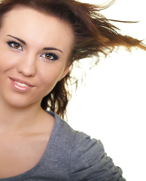 Porträt einer glücklichen jungen Frau im grauen Hemd. Haare in Bewegung. — Stockfoto