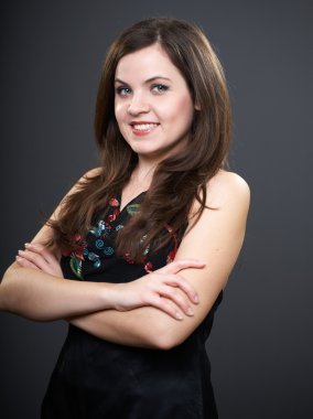 siyah bluz çekici bir genç kadın. katlanmış h ile ayakta