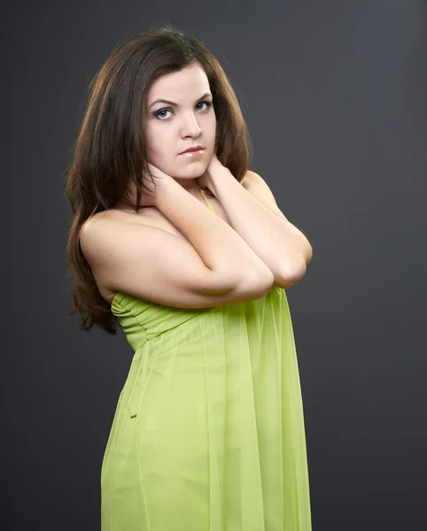 Atraktivní mladá žena v zelených šatech. žena objímala krku. — Stock fotografie