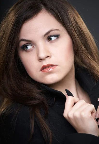 Retrato de una joven atractiva con una chaqueta negra. Mirando a —  Fotos de Stock