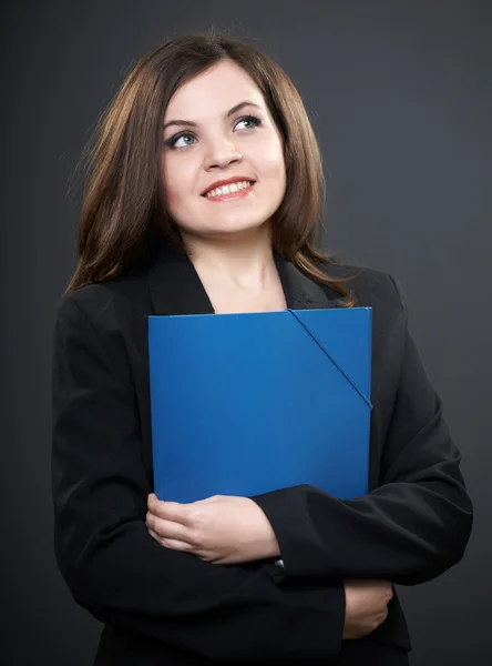 Attractive young woman in a black jacket. Holds a blue folder an — Stock Photo, Image