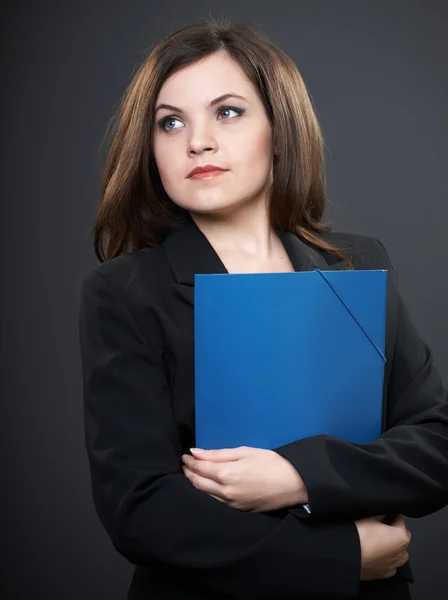 Attraktive junge Frau in schwarzer Jacke. hält einen blauen Ordner mit einem — Stockfoto